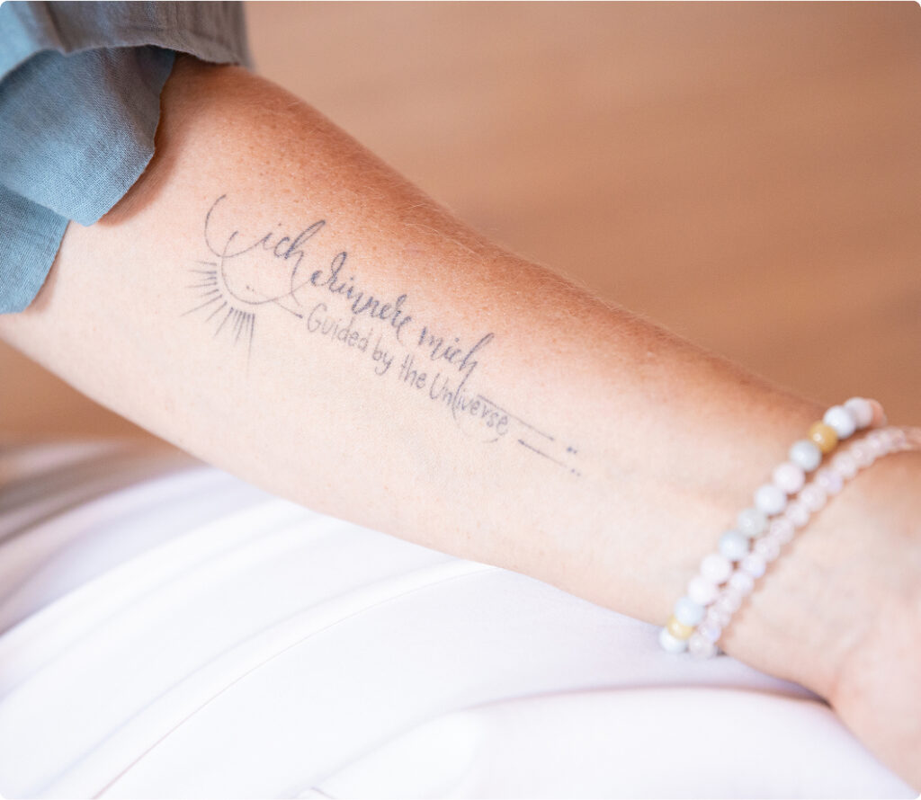 Tattoo auf Andreas Arm mit der Aufschrift Guided by the Universe